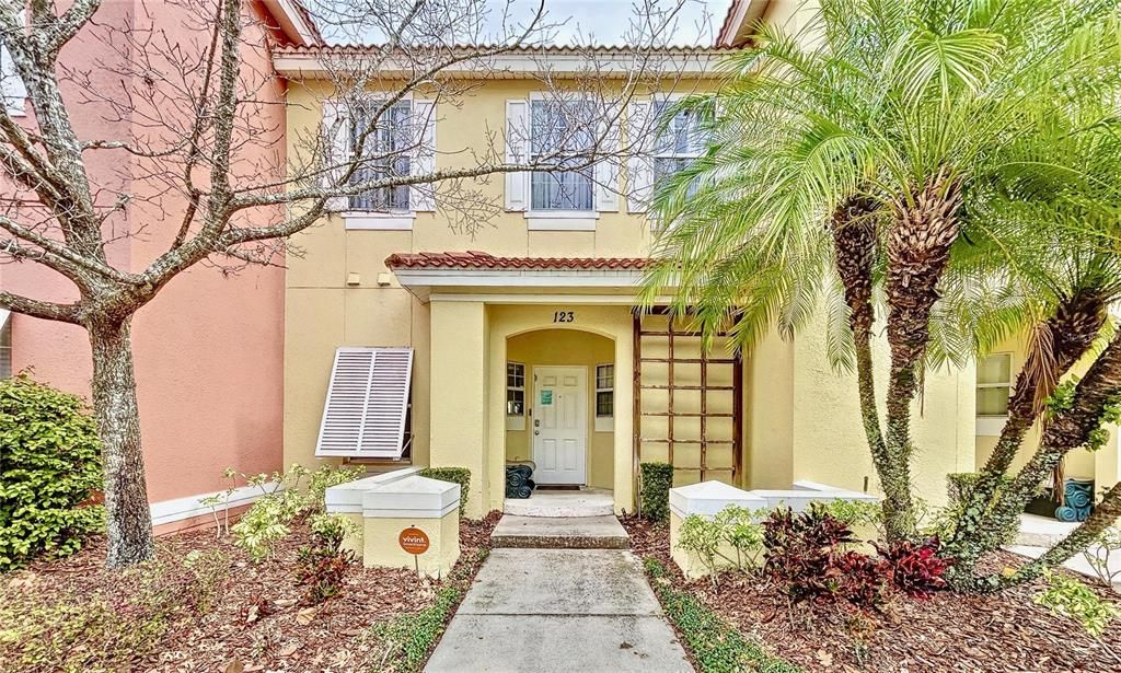 Terra Verde townhome with terracotta roof, palms, and flowers